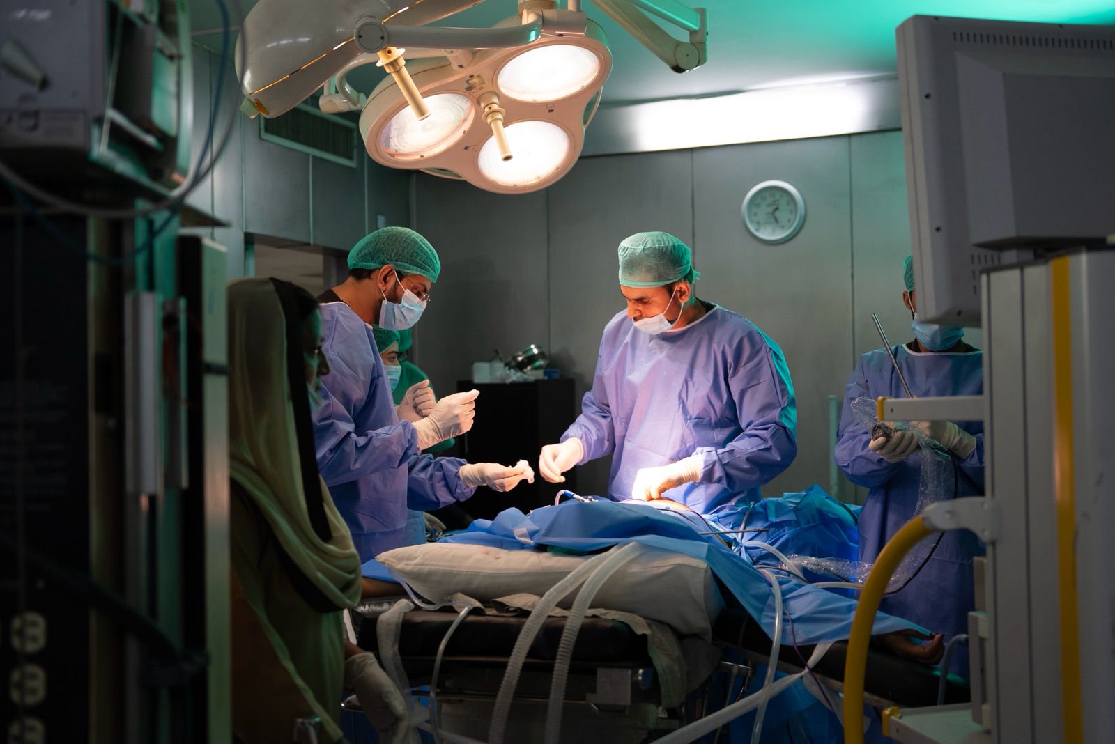 Bariatric surgeon performing a procedure in an operating room, representing medical and surgical treatment options for obesity.